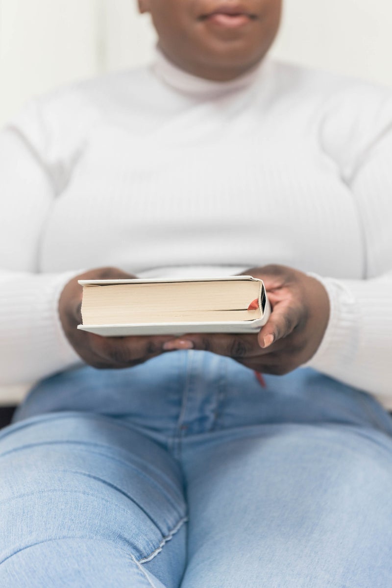 Close up of Black feminine hands holding a closed book