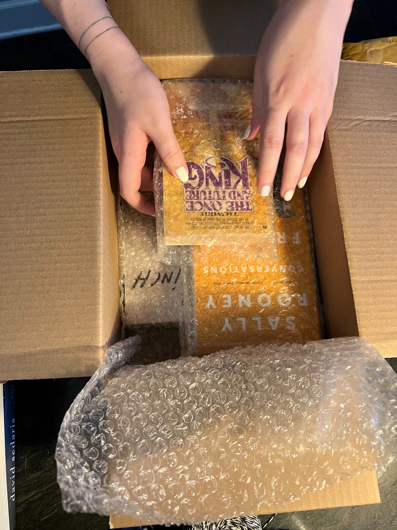 A cardboard box with books in bubble wrap ready to be mailed.