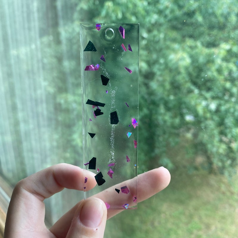 3.81” by 1.81” black and pink foil resin bookmark