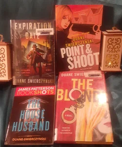 4 Duane Swierczynski noir book lot Blonde, Expiration Date, Point and Shoot, and rhe Hoyse Husband. 
Blonde and Expiration Date are ex-library copies with stamps and markings. 
Pint and Shoot, and House Husband have minor cover dings.
